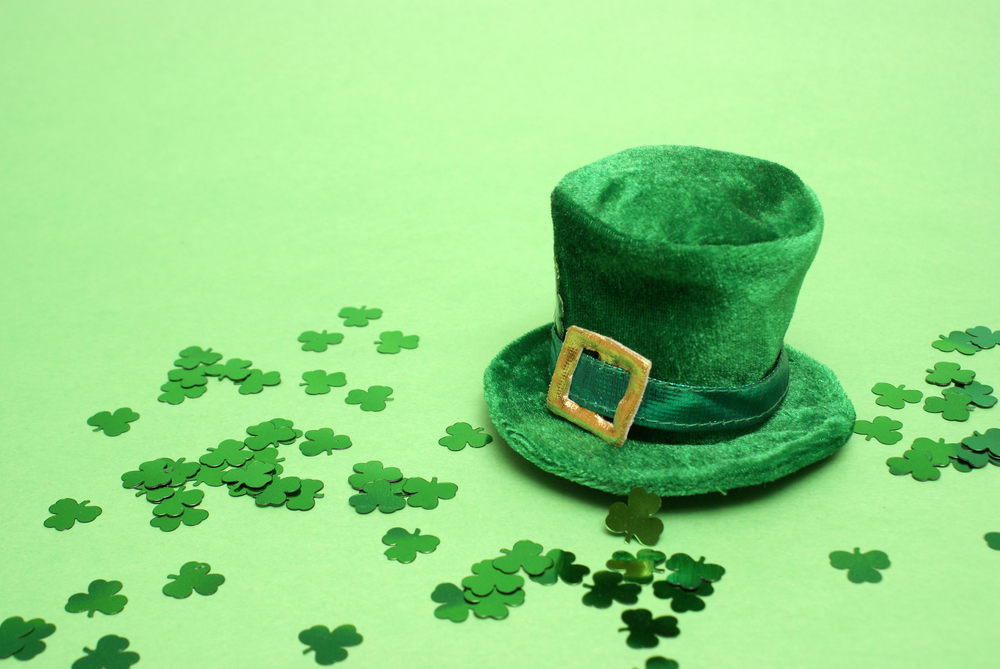 St. Patrick's Day Green Top Hat with green 3 leaf clovers scattered on green background St. Patrick's Day Green Top Hat with green 3 leaf clovers scattered on green background