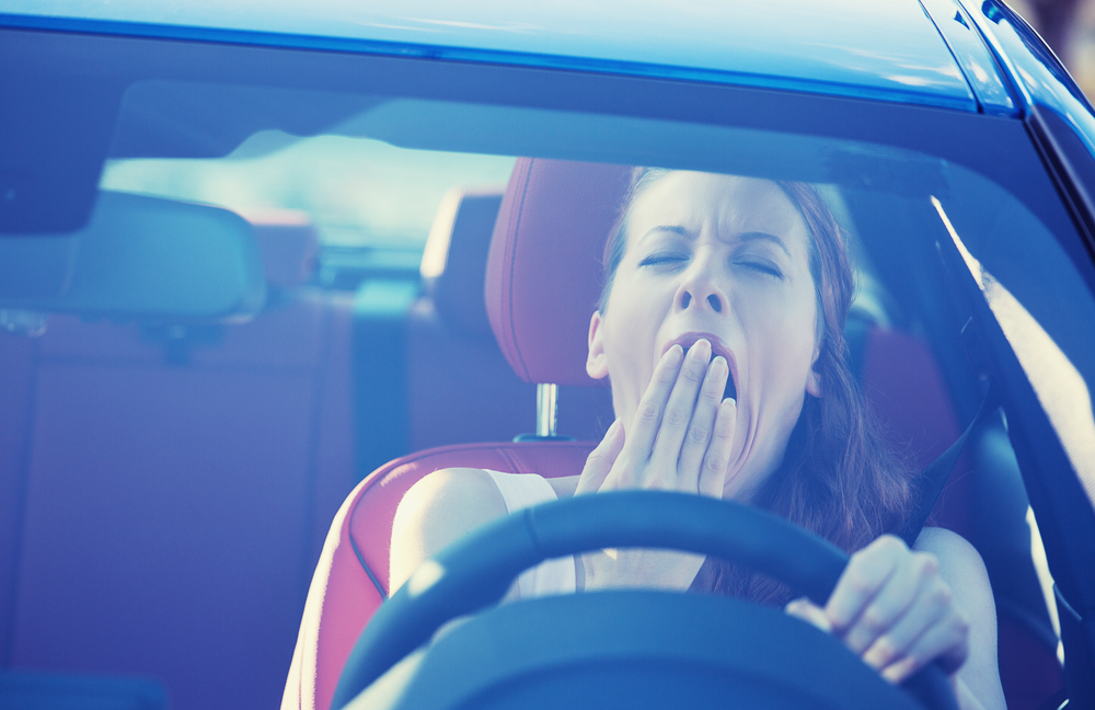 Drowsy woman yawning while driving